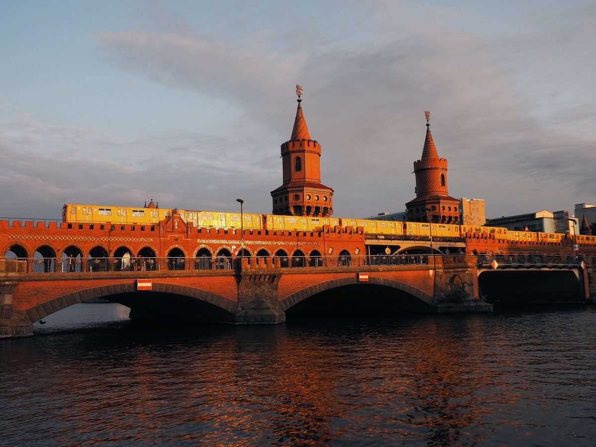 Oberbaum Bridge over the Spree in Berlin at sunset, with a train crossing